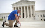 Former assistant football coach Joe Kennedy took a knee in front of the U.S. Supreme Court building after his legal case, Kennedy vs. Bremerton School