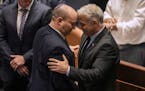 Israeli Prime Minister Naftali Bennett, left, and Foreign Minister Yair Lapid react after a vote on a bill to dissolve the parliament at the Knesset, 