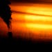 Emissions from a coal-fired power plant are silhouetted against the setting sun in Kansas City, Mo., Feb. 1, 2021. 