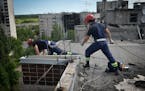 Ukrainian rescuers dismantle the roof of a high-rise building damaged by Russian shelling in one of the residential areas of Kharkiv, Ukraine, Thursda