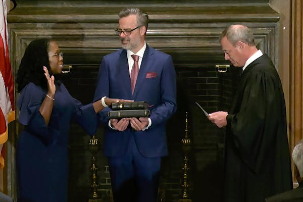 In this image from video, Chief Justice John Roberts administered the constitutional oath to Ketanji Brown Jackson as her husband, Patrick Jackson, he