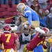 UCLA quarterback Dorian Thompson-Robinson hurdles high over USC safety Chase Williams, left, and cornerback Isaac Taylor-Stuart when the teams played 