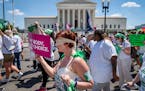 Mahayana Landowne, of Brooklyn, N.Y., wears a “Lady Justice” costume as she marches past the Supreme Court during a protest for abortion-rights, T