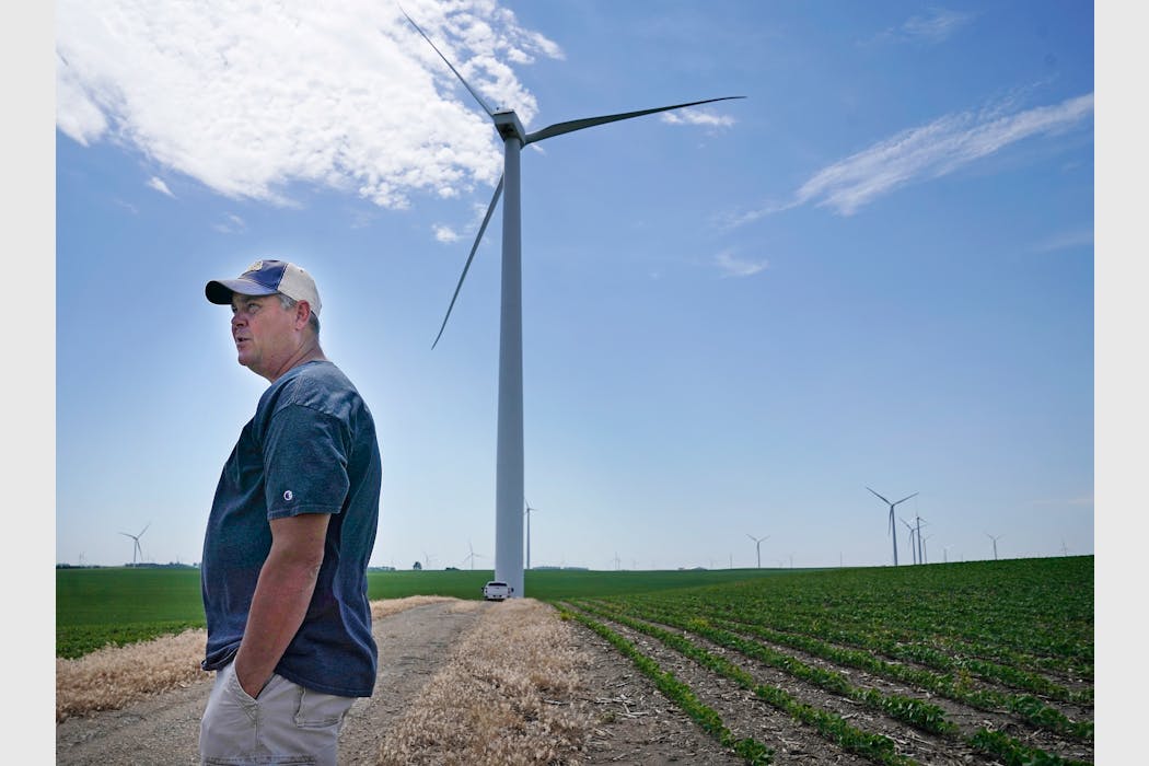 Mike Kluis, Fenton Township supervisor, stands along a wind farm access road and next to his soybeans plants and where power line congestion is increa