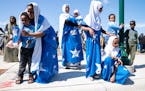 Afnan Warsame, 10, left, dances with her family during the Somali Independence Day festival Saturday, July 2, 2022 on Lake Street in the Whittier neig
