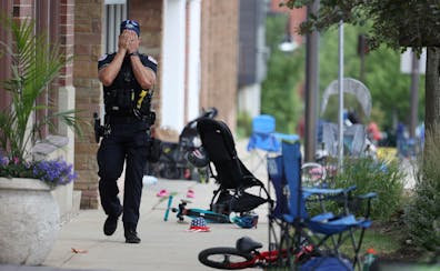 A Lake County police officer walks down Central Ave in Highland Park, Ill. on Monday after a shooter fired on the northern suburb’s Fourth of July p