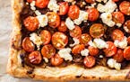 Caramelized onions, goat cheese and tomatoes combine to make a tart that’s delicious served warm or at room temperature.