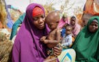 Nunay Mohamed, 25, who fled the drought-stricken Lower Shabelle area, holds her one-year old malnourished child at a makeshift camp for the displaced 