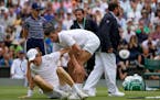 Serbia’s Novak Djokovic helps Italy’s Jannik Sinner to his feet after he slipped while chasing down a ball in their quarterfinal match.