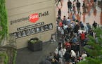 Lines of fans wait to go through added security while a bomb-sniffing dog and its handler look on at Guaranteed Rate Field after a Fourth of July para