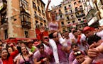 Revelers celebrate while waiting for the launch of the ‘Chupinazo’ rocket, to mark the official opening of the 2022 San Fermin fiestas in Pamplona