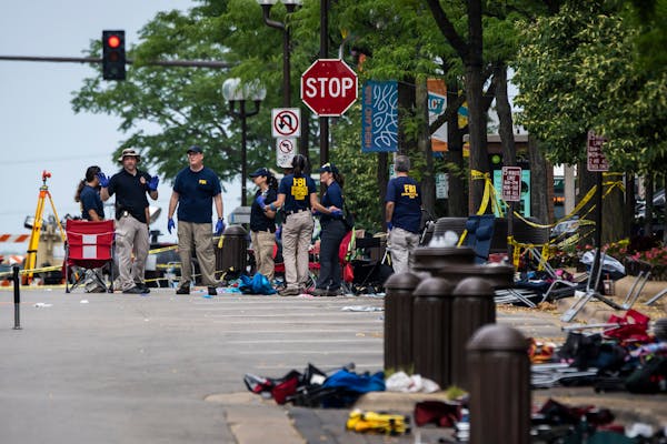 Members of the FBI’s Evidence Response Team Unit investigate in downtown Highland Park, Ill., on July 5, the day after a deadly mass shooting. Polic