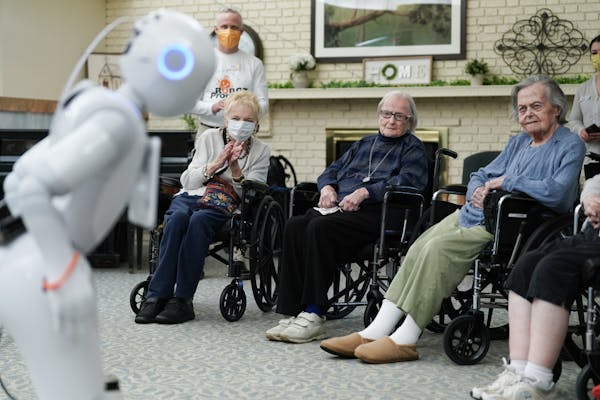 Nursing home residents Carol Jones, Carol Fisher, and Irene Struck listened as Pepper, a new robotic assistant, performed an adult-themed comedy routi