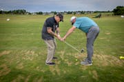 Golf pro John Kellin, right, helped Geno Mucciacciaro with his swing as military veterans received free lessons through the PGA Hope program Wednesday