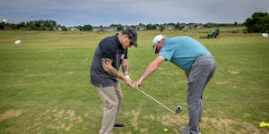 Golf pro John Kellin, right, helped Geno Mucciacciaro with his swing as military veterans received free lessons through the PGA Hope program Wednesday