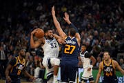 Minnesota Timberwolves center Karl-Anthony Towns (32) drove into Utah Jazz center Rudy Gobert (27) while heading to the rim in the third quarter. ] JE