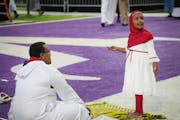 Faduma Omar, 4, looks up at the Jumbotron as her father Shueib Hassan from Eagan watches over her. 
