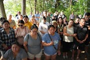 Community members stood Saturday during a vigil held by family of Yee Lee and Molly Cheng at the site where rescuers found the bodies of Cheng and the