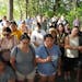 Community members stood Saturday during a vigil held by family of Yee Lee and Molly Cheng at the site where rescuers found the bodies of Cheng and the