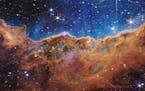 This landscape of “mountains” and “valleys” speckled with glittering stars is actually the edge of a nearby, young, star-forming region called