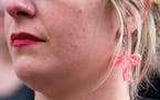 Ashley Weaver wears uterus earrings during a vigil on June 24 in Minneapolis in response to the Dobbs v. Jackson Women’s Health decision issued by t
