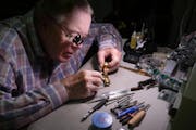 Bob Tuerk, owner of House of Clocks, puts a new battery into a wristwatch Wednesday, July 15, 2022 at his shop in St. Paul, Minn.