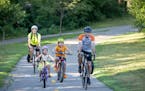 Emma and Brian Bellemare and their children Camden, 8, right, and Vienna, 5, left, biked to Vienna’s summer program before the adults went off to wo