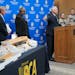 Gov. Tim Walz gestures toward a table of confiscated guns used in statewide crimes during a press conference at the BCA, Thursday, July 21, 2022 in Sa