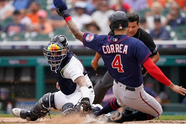 Twins star Carlos Correa beat the tag of Tigers catcher Eric Haase to score during a three-run top of the first inning Sunday in Detroit.