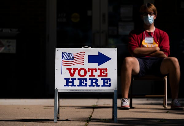 An election judge directs voters outside a polling place in the Pearl Park Recreation Center in Minneapolis on August 11, 2020.
