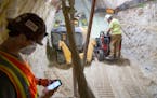 Foreman Eric Fobbe operated a remote-controlled robot as Jaden Wisti removed sandstone as they carved out a new storm water tunnel Thursday, July 28, 