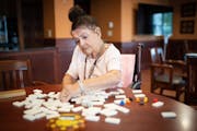 LaVonne Borsheim, 88, set up a game of dominoes for a weekly game she plays with fellow residents at her assisted living home on Wednesday, July 27, 2