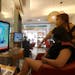 A customer and a staff member watch a news report on the recent tensions between China and Taiwan, at a beauty salon in Taipei, Taiwan, Thursday, Aug.