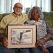 Nathaniel Khaliq and his wife, Vicky Davis, of St. Paul held a photo of Khaliq’s grandfather being taken out of his Rondo home in handcuffs. 