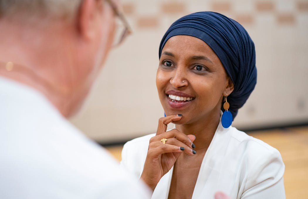 Rep. Ilhan Omar speaks to Greg Backlund after a town hall meeting at Lakeview Elementary School in Robbinsdale on Thursday, Aug. 4. 
