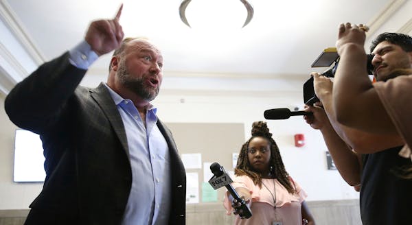 Alex Jones talks to media during a midday break during the trial at the Travis County Courthouse in Austin, Texas, Tuesday, July 26, 2022. 