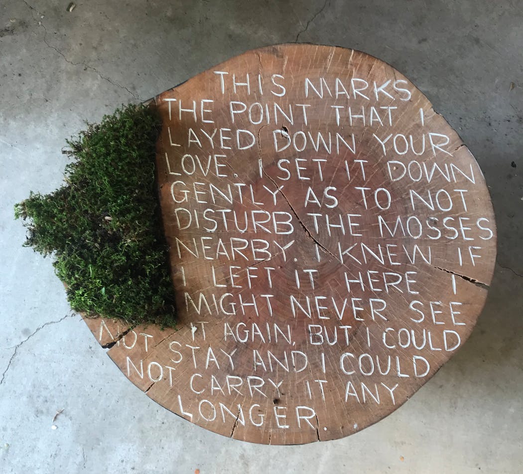 Artist Julie Benda uses a hammer and a gouge to carve text into her wood sculptures.