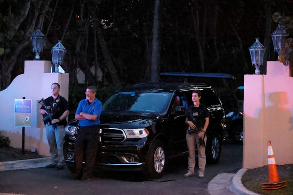 Armed Secret Service agents stand outside an entrance to former President Donald Trump’s Mar-a-Lago estate late Monday in Palm Beach, Fla.