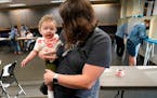 Voter Lydia Beattie of Minneapolis holds her son Faris, 6 months, after Beattie voted Tuesday at Powderhorn Park.