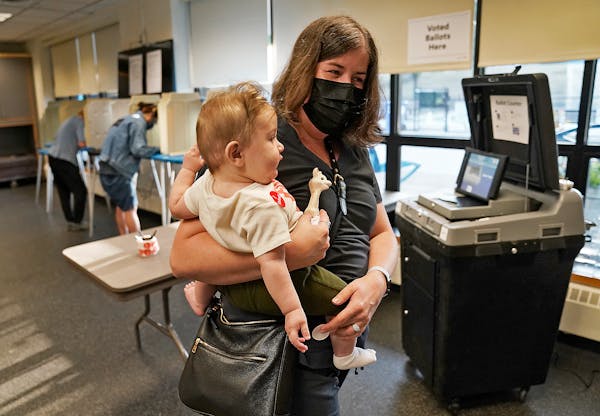 Voter Lydia Beattie of Minneapolis held son Faris, 6 months, at a polling place in Powderhorn Park on Tuesday.