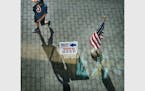 A man cast a shadow while walking by a voting sign at the Minneapolis Central Library during the primary election that includes the 5th Congressional 