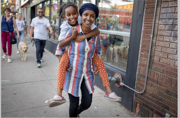 U.S. Rep. Ilhan Omar carried her youngest daughter Ilwad Hirsi, 10, during a voter engagement event near the Target at the University of Minnesota cam