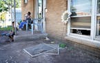 Displaced residents Denise Meanweather and her grandson sat Wednesday outside the front door of their apartment building in north Minneapolis. The fam