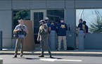In this image taken from video, FBI officials gather outside the FBI building in Cincinnati, Thursday, Aug. 11, 2022.