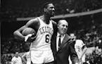 Bill Russell was congratulated by coach Red Auerbach after scoring his 10,000th point in 1964. Russell died on July 31.