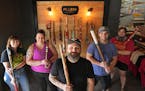 Zak Fellman (Center) holding the first bat that he carved as a kid, and his crew at Pillbox Bat Company. Sarah Roberts, Carrie Frederich, Kyle Wright 