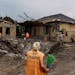 A worker arrived with a broom at a crater caused by a rocket strike on a house in Kramatorsk, Donetsk region, eastern Ukraine, Friday, Aug. 12, 2022. 