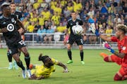 Minnesota United goalkeeper Dayne St. Clair moved over to stop the attack of Nashville SC forward C.J. Sapong, with the help of defender Bakaye Dibass