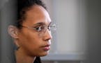 Brittney Griner sits inside a defendants’ cage before a hearing outside of Moscow in July.