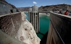 Visitors walk around the Hoover Dam, where severe and prolonged drought conditions have exposed the rocky sides of Black Canyon and the intake towers 